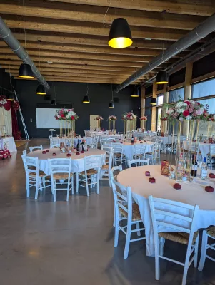 Sophisticated country-style table centrepiece with roses, white hydrangeas, and pink alstroemerias for a wedding.