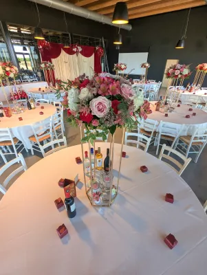 Sophisticated country-style table centrepiece with roses, white hydrangeas, and pink alstroemerias for a wedding.