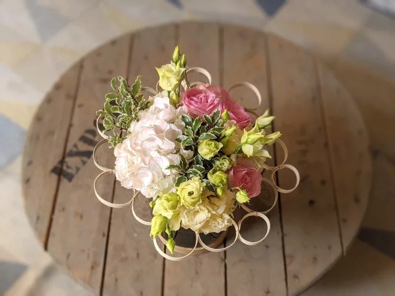 A classic wedding table centrepiece with roses, hydrangeas and lisianthus in a soft and natural arrangement.