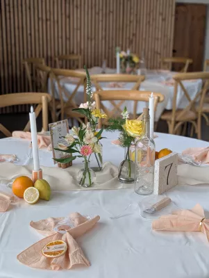 Centre de table champêtre sophistiqué avec roses pâles, alstroemerias et feuillages verts pour un mariage.