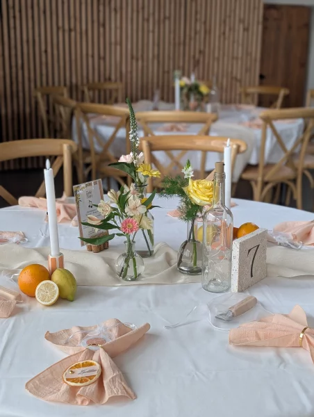 Centre de table champêtre sophistiqué avec roses pâles, alstroemerias et feuillages verts pour un mariage.