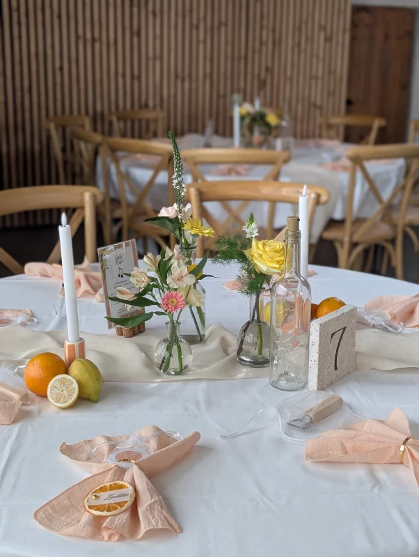 Sophisticated rustic table centrepiece with pale roses, alstroemerias, and lush greenery for a wedding.