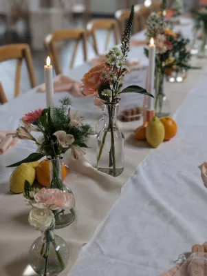 Centre de table champêtre sophistiqué avec roses pâles, alstroemerias et feuillages verts pour un mariage.