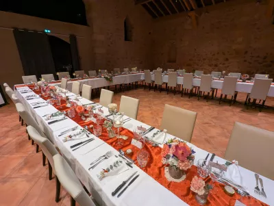 Sophisticated rustic centrepieces with roses, orange carnations, and green foliage for a wedding in Pessec.