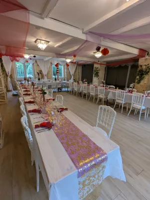 Centre de table exotique classique avec roses rouges et blanches, feuillage vert, décorations de mariage Le Grand Moueys Capian.