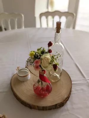 Centre de table champetre avec roses roses, gypsophile et baies rouges pour un mariage en ete au Domaine De Larchey.