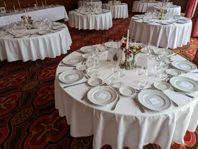 Centre de table rond classique avec roses rouges et alstroemerias blanches, bougie dorée, pour un mariage à Pessac.