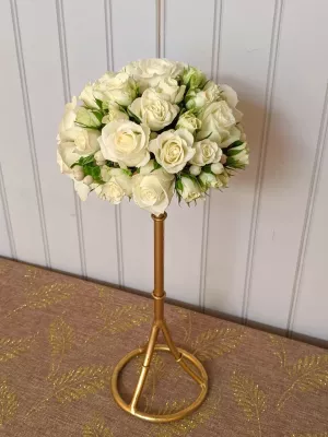 Arrangement floral de mariage classique, avec un dôme de roses blanches et de baies claires, élevé sur un élégant support doré.
