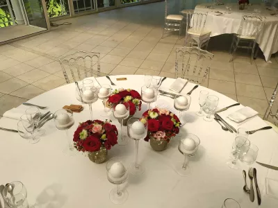 Centres de table de mariage style classique avec roses rouges et roses, chrysanthèmes, dans des vases dorés à Arcachon.