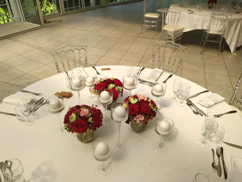 Centres de table de mariage style classique avec roses rouges et roses, chrysanthèmes, dans des vases dorés à Arcachon.