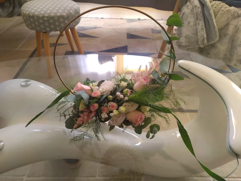 Round table centrepiece with powder pink roses, gypsophila and eucalyptus, romantic country style for a wedding.