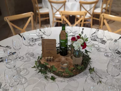 Centre de table champêtre avec rondin de bois, lierre, roses blanches et rouges, alstroemeria et une fleur rouge pompon pour mariage.