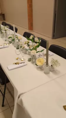 Décoration de centre de table classique pour un mariage, avec roses crème, gypsophile et verdure élégamment disposés.
