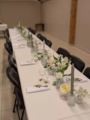 Décoration de centre de table classique pour un mariage, avec roses crème, gypsophile et verdure élégamment disposés.