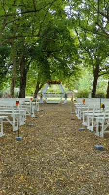 Ceremony aisle with floral arch and small suspended bouquets at Domaine de Valmont.