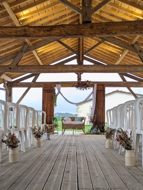 Sophisticated country-style ceremony aisle with terracotta and orange dried flower arrangements for a wedding.