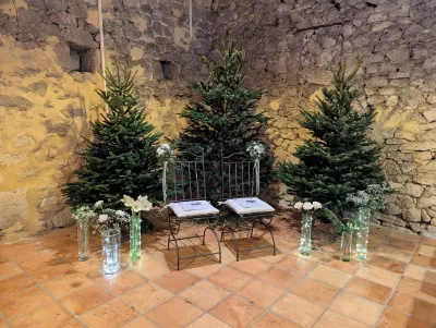 Décoration de cérémonie classique avec de grands sapins, arrangements floraux blancs et lumières, mariage à Saint-Vincent-de-Pertignas.