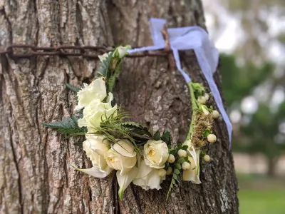 Couronne florale de mariée style exotique, avec roses blanches, fougères et feuillage texturé pour un mariage d'automne.