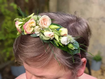 Peigne floral champêtre pour mariage, agrémenté de roses pêche, de roses blanches et de feuillage varié, harmonieux.