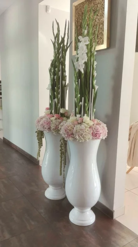 Colonnes décoratives florales classiques pour un mariage, avec des glaïeuls blancs, hortensias roses et roses.