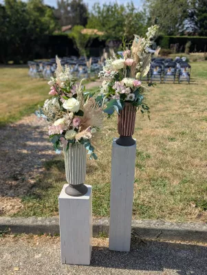 Floral columns with white and pink roses, eucalyptus and pampas grass for a country wedding ceremony.
