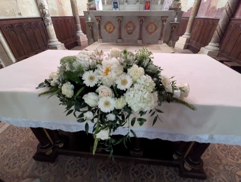 A grand white floral display for a church altar, featuring hydrangeas, roses, and gerberas, in a classic and elegant style.