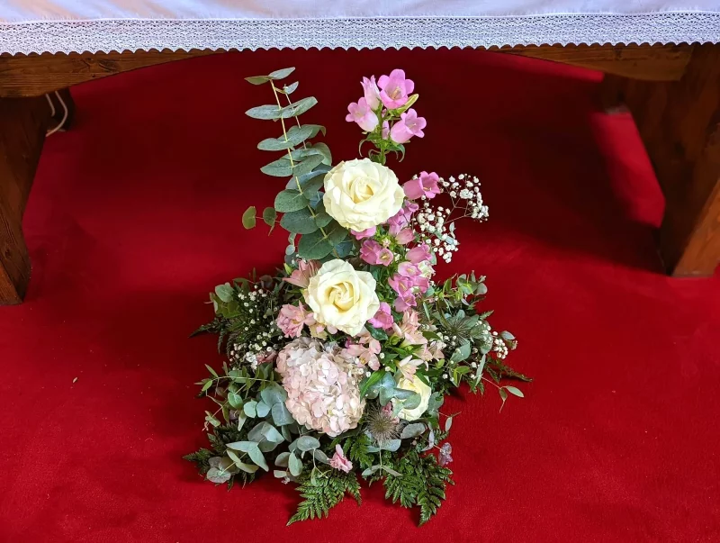 Grand ceremony floral display in a countryside style, featuring cream roses, pink hydrangeas, fuchsia snapdragons, and eucalyptus.
