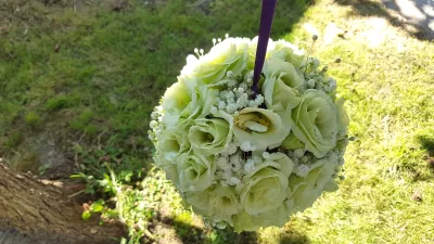 Composition florale suspendue avec des eustomas vert pâle et du gypsophile, créant une ambiance fraîche et minimaliste.