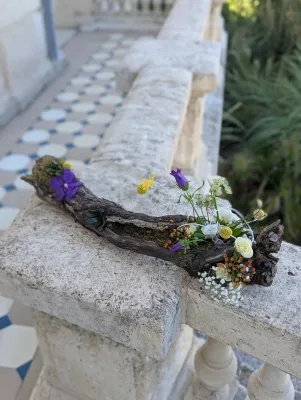 Bohemian botanical floral design on driftwood with white roses, purple campanulas and succulents.