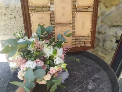 Composition florale champêtre avec roses, eucalyptus et astilbe pour le plan de table d'un mariage