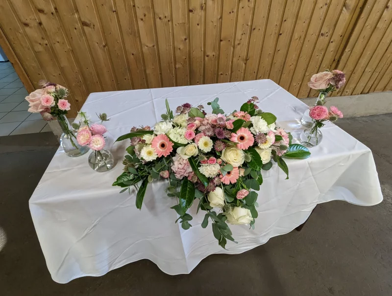 Lengthy countryside-inspired floral arrangement with roses and gerberas for a Bordeaux wedding