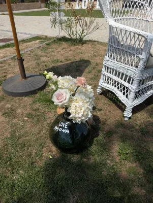 Sophisticated country floral arrangement with roses, hydrangeas, and carnations in a glass vase.