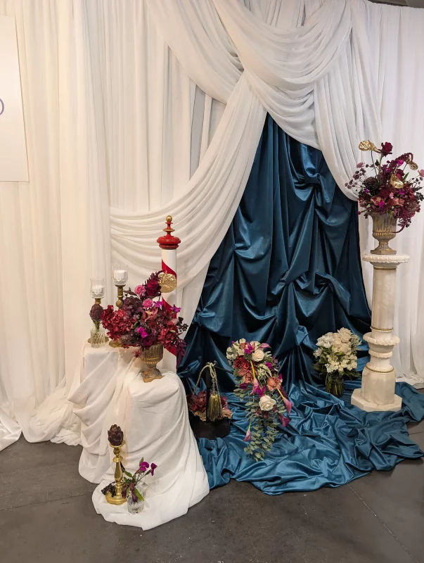 Classic and exotic floral design featuring burgundy roses, golden anthuriums and magenta orchids for a wedding fair in Bordeaux.