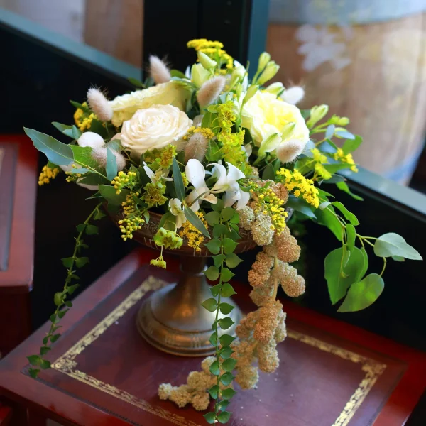 Composition scénographique bohème avec roses blanches et jaunes, freesias, eucalyptus et herbe de la pampa.