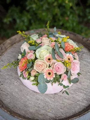 Couronne florale champêtre pour mariage, avec roses, gerberas roses, œillets corail et eucalyptus.