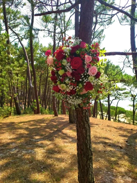 Décoration d'arbre florale style classique avec roses rouges et roses, chrysanthèmes et gypsophile, pour un mariage.