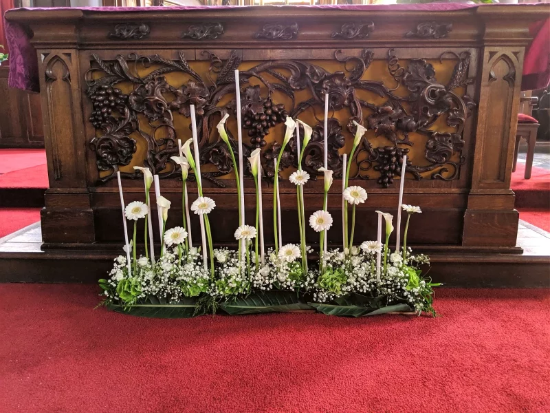 Classic wedding altar decoration, with rows of calla lilies, gerberas and gypsophila surrounding tall candles.