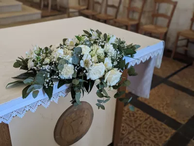 Composition florale élégante pour l'autel de cérémonie avec roses blanches, eucalyptus et gypsophile.