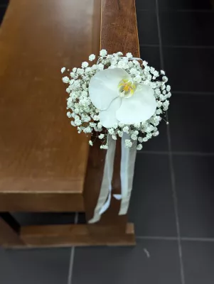 Décoration de banc de cérémonie de mariage classique avec une orchidée blanche unique et du gypsophile.