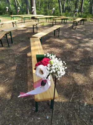 Décoration d'allée de cérémonie style champêtre avec roses rouges, gypsophile et eustoma, pour un mariage.