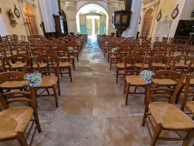 Décoration d'allée de cérémonie avec de petits bouquets de gypsophila et chrysanthèmes sur les chaises, style champêtre.