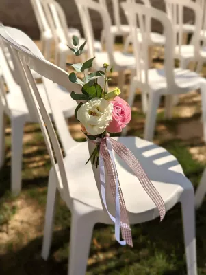 Décoration de chaise champêtre avec rose blanche et rose, eucalyptus, rubans pour cérémonie de mariage.