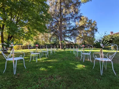 Décoration de chaises de cérémonie exotique avec feuilles de palmier, roses roses et eustoma au Domaine Pascaud à Rions