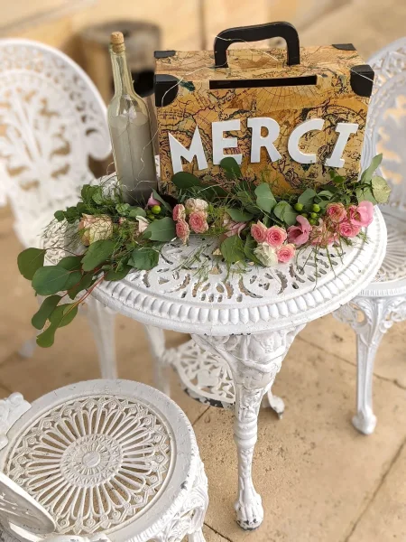 Décoration de table 'Merci' de mariage champêtre avec roses miniatures et feuillage eucalyptus.