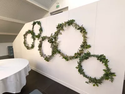 Décoration murale végétalisée avec des cercles de feuillage vert, créant une ambiance champêtre pour un mariage à Léognan.