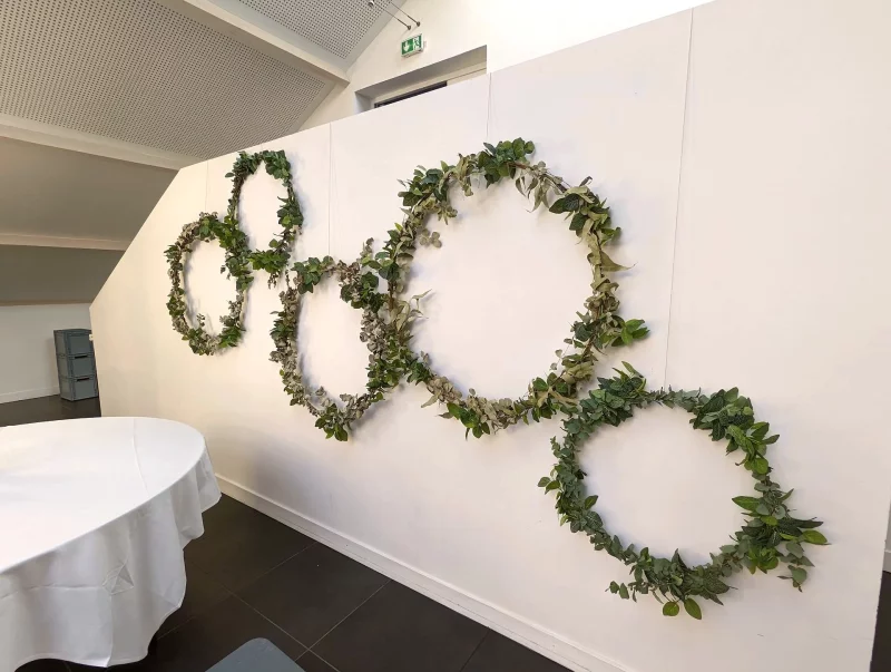 Décoration murale végétalisée avec des cercles de feuillage vert, créant une ambiance champêtre pour un mariage à Léognan.