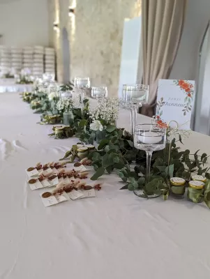 Détail de la décoration florale de la table d'honneur avec eucalyptus, gypsophile et roses blanches.