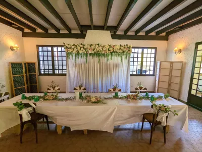 Décoration de table d'honneur champêtre avec guirlande d'eucalyptus, roses poudrées, astilbe et gypsophile.