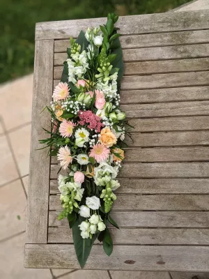 Décoration de table de mariage style champêtre, chemin de fleurs roses, blanches et pêche avec roses, gerberas et lisianthus.