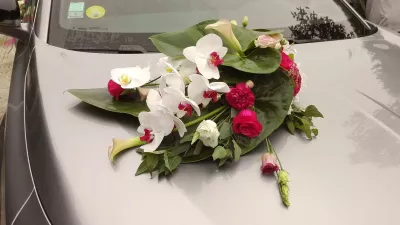 Décoration de véhicule de mariage classique, avec des orchidées blanches, des roses fuchsia et des callas.